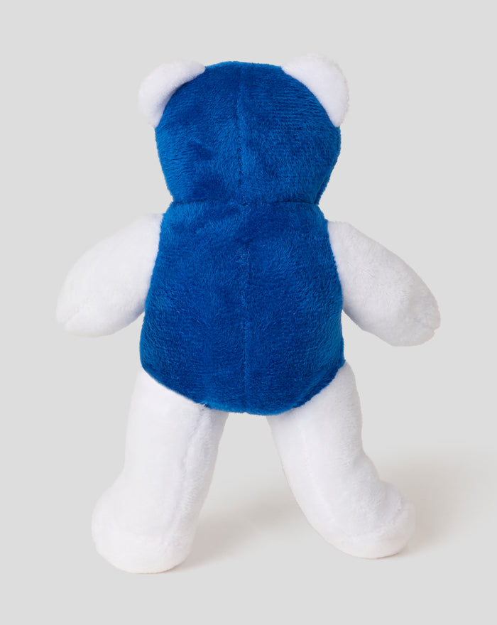 Back view of a blue plush bear with white ears and limbs against a light gray background.
