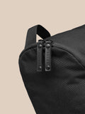Close-up of black Castore boot bag showing twin zipper pulls and a top strap.