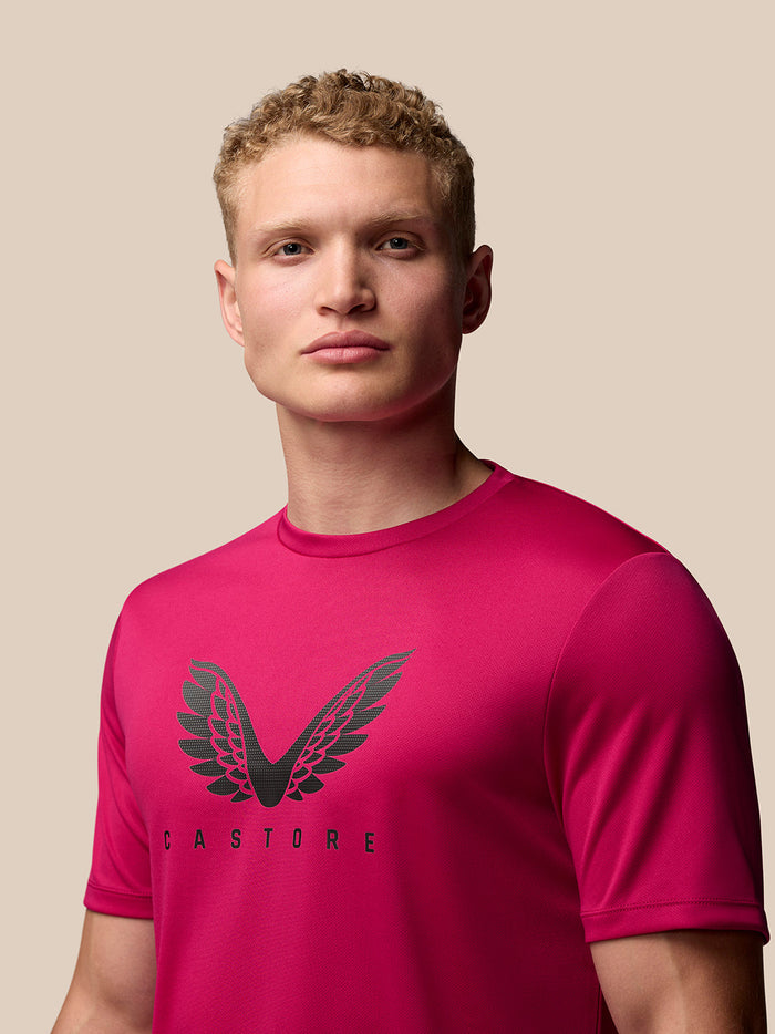 Man wearing pink ADAPT Training T Shirt with Castore wings on chest