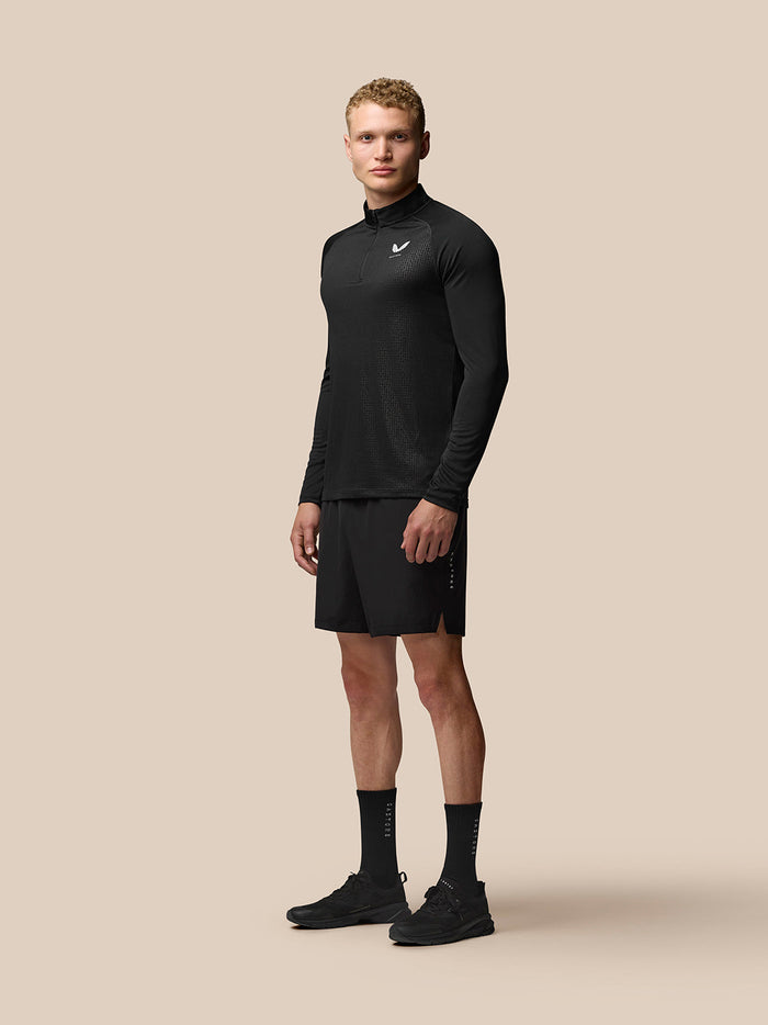 Male model wearing black Adapt Print 1/4 Zip Top with stand collar and geometric pattern.