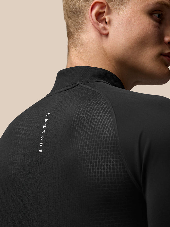 Back view of black Adapt long sleeve quarter zip top with stand collar and geometric pattern