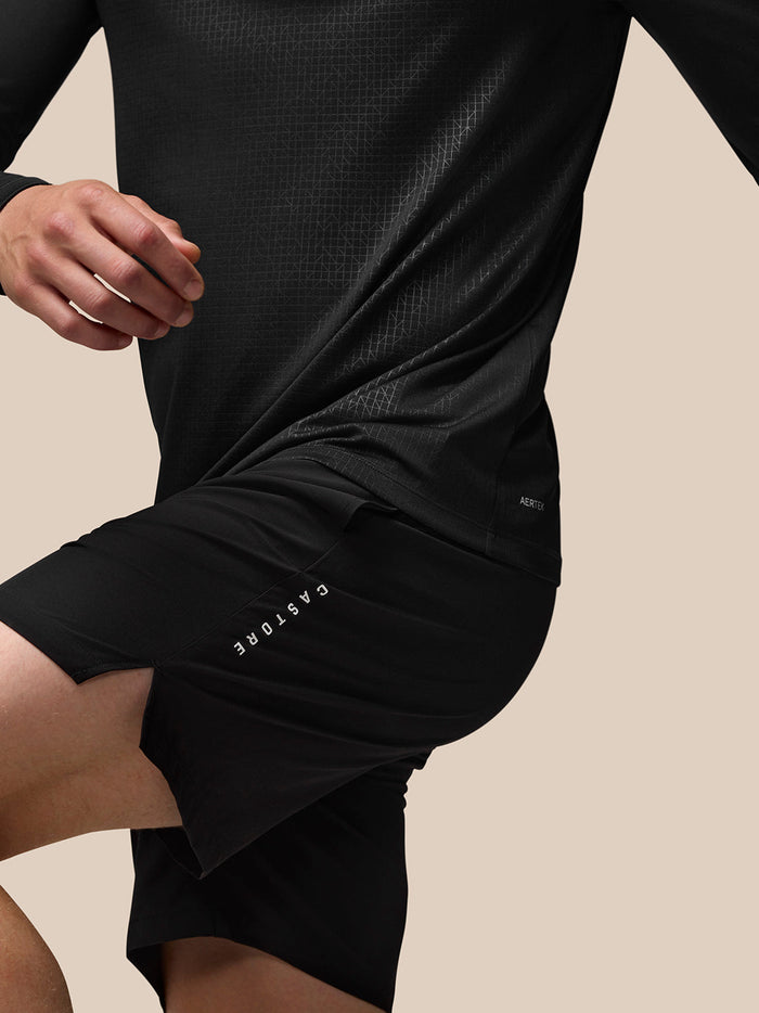 Back view of black Adapt top showing geometric print and Aertek label at the lower back with Castore branding on shorts