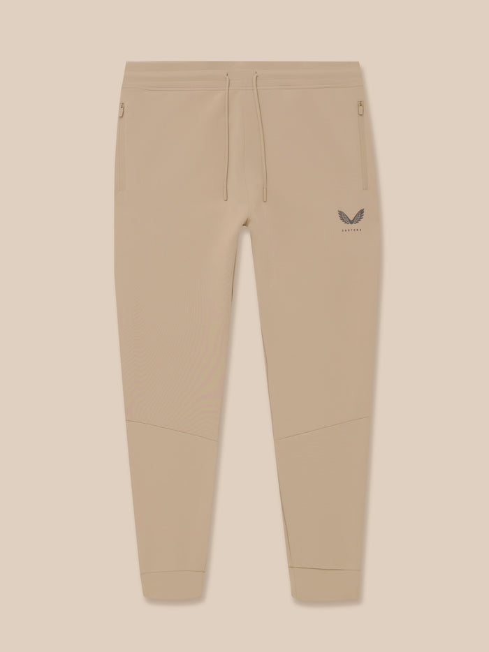 Front view of mushroom Flex Lifestyle joggers with drawcord waist and zip pockets; Castore logo on left leg