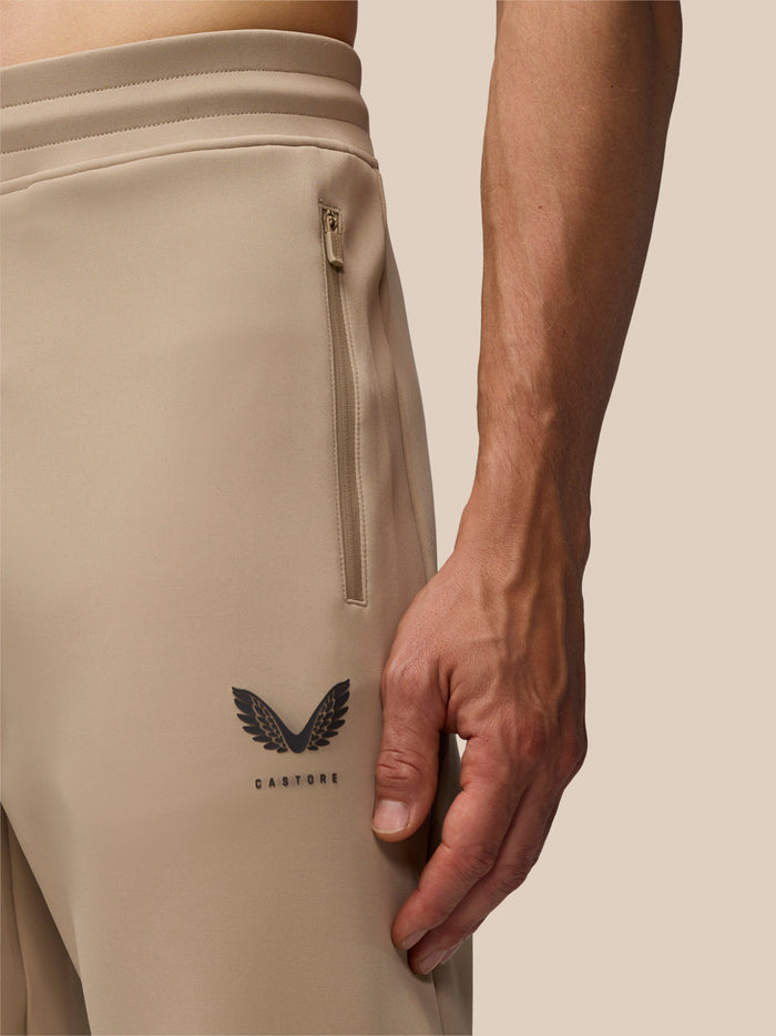 Close-up of beige Flex Lifestyle Joggers with a vertical hip zip pocket and Castore branding on the leg