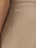 Close-up of beige fabric showing PROTEK logo and water droplets, highlighting water resistance.