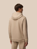 Back view of a man in mushroom Flex Lifestyle Hoodie showing the hood and clean silhouette