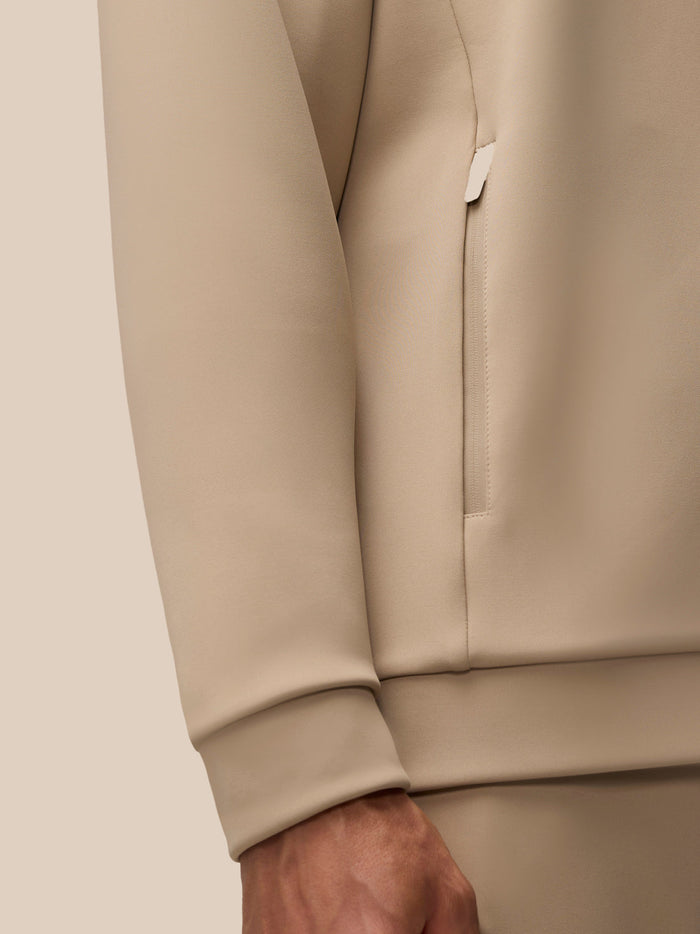 Close-up of the beige Flex Lifestyle Hoodie sleeve cuff and lower arm in knit fabric.