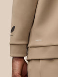 Close-up of beige sleeve featuring ProTek logo and Castore wing emblem