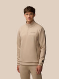Male model wearing mushroom beige Flex Lifestyle 1/4 zip top with front center zipper and Castore logo on chest