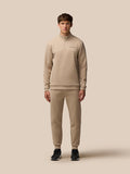 Male model in matching mushroom beige Flex Lifestyle scuba quarter zip top and joggers with zip pockets