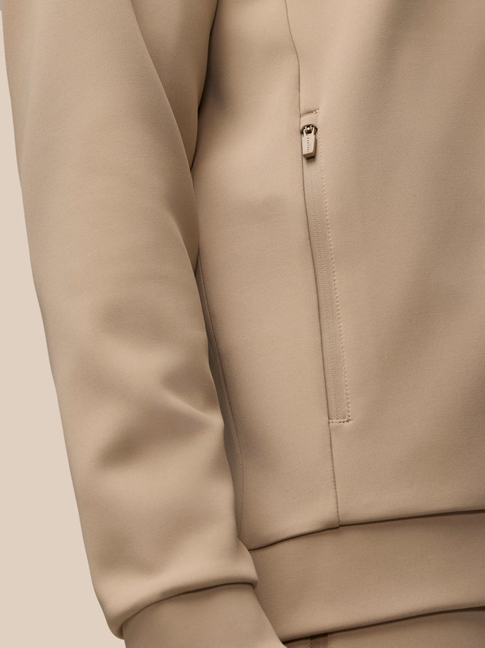 Beige mushroom gunmetal Flex Lifestyle quarter zip top with front zipper and zipped pockets.