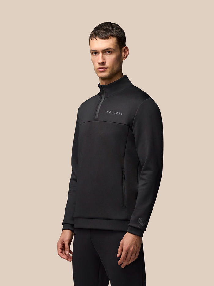 Male model wearing black Castore Flex Lifestyle 1/4 zip top with zip pockets