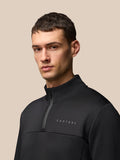 Close-up of a male model wearing a black FLEX LIFESTYLE 1/4 ZIP top with high collar and Castore branding on the chest