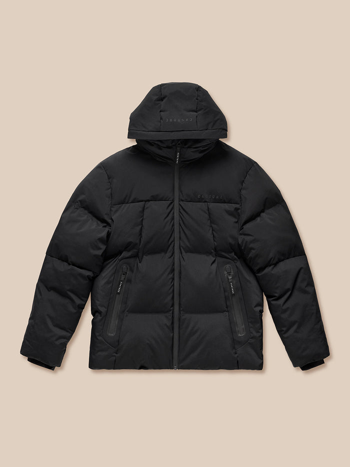 Black puffer jacket with hood front zip, two zip pockets, and Castore branding on chest and right sleeve