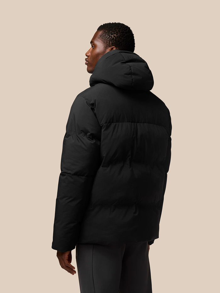 Back view of a man in a black Castore puffer jacket with a hood