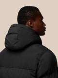 Back view of a man in a black hooded puffer jacket with CASTORE branding on the hood