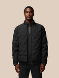 Man in black padded jacket with stand collar and full front zip against a neutral beige background