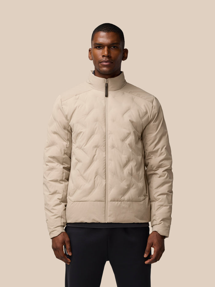 Man wearing beige padded jacket with front zip and quilted panels