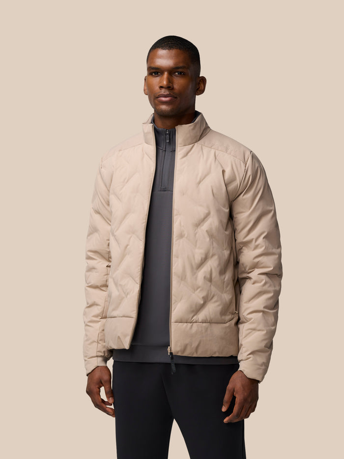 Male model wearing mushroom padded jacket front view highlighting ProTek water resistant fabric and zip pockets
