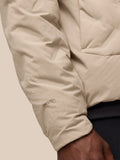 Beige padded jacket sleeve with visible water droplets and ProTek branding near the cuff