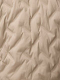Beige fabric close up with a fine grid texture from the mushroom padded jacket.