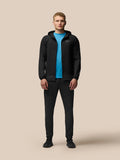 Full body view of a model wearing a black FLEX WINTERISED JACKET with hood down and blue top underneath