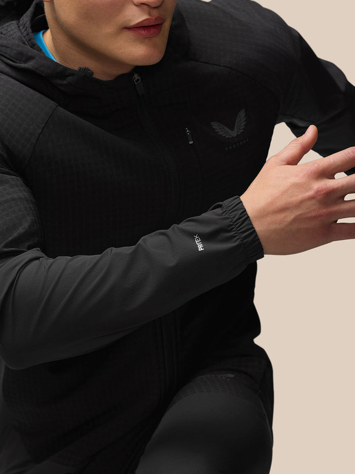 Front view of a model in a black FLEX WINTERISED JACKET zipped up with black pants and sneakers