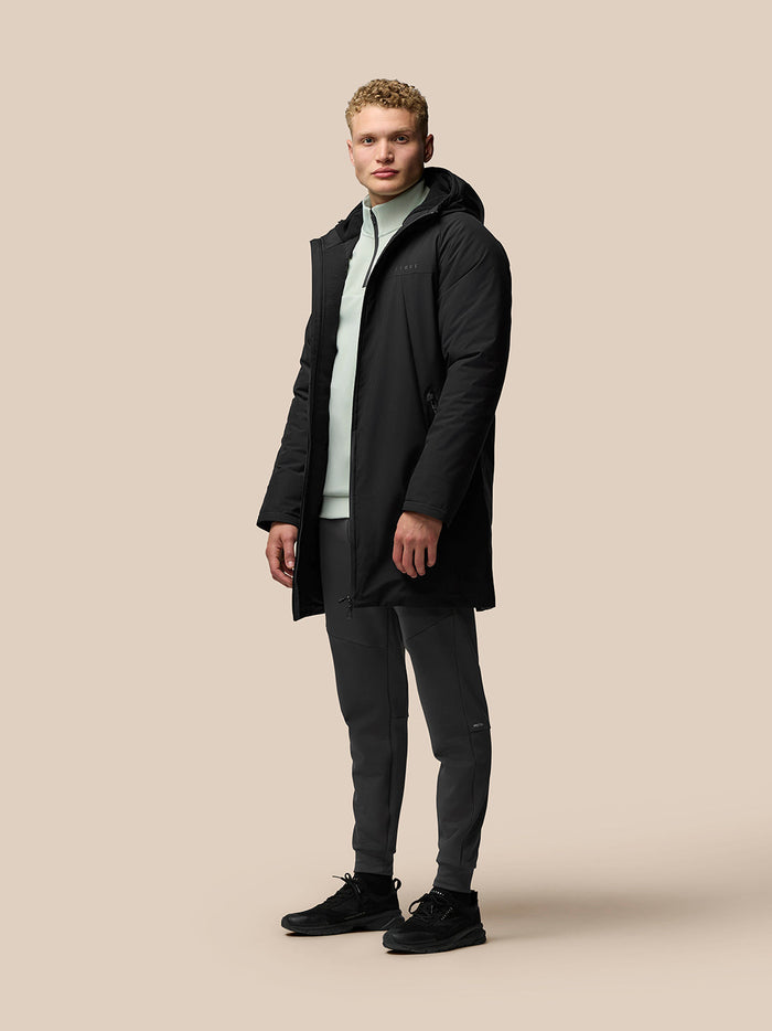 Male model wearing black longline ProTek water resistant jacket with hood, full front zipper and external pockets.
