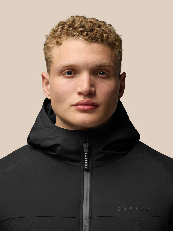 Model wearing black longline wadded jacket with hood and front zipper
