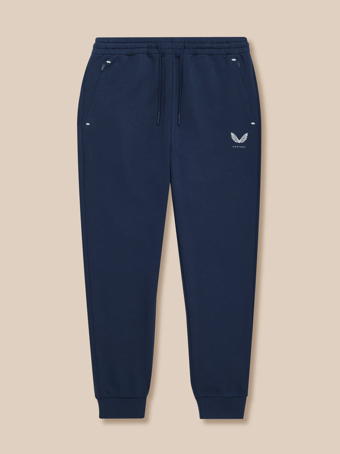 Navy Travel Lifestyle Joggers front view with zip pockets and Castore logo on front left thigh