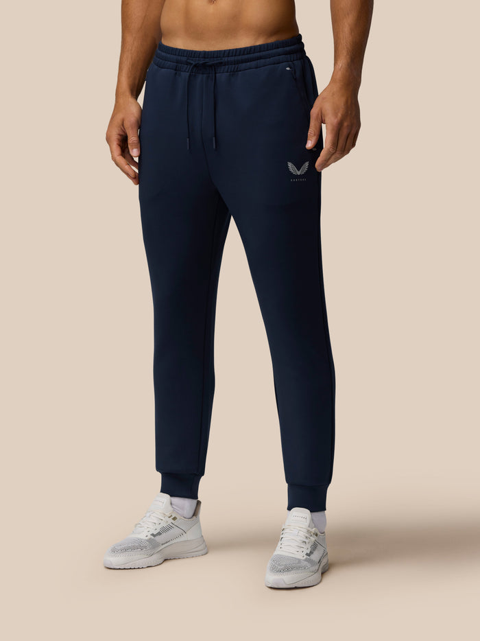 Model wearing navy Travel Lifestyle Joggers with tapered fit and Castore logo on the front.