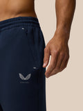 Close up of navy travel joggers waist and hip area showing a concealed pocket zipper and Castore logo.