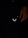 Close up of navy travel joggers leg with the Castore logo on the thigh and a hand resting nearby.