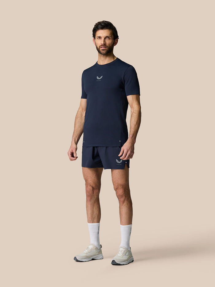 Male model wearing Zone Training T Shirt Midnight Navy with matching shorts against a beige backdrop