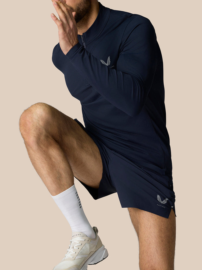 Male model wearing navy Zone Training 1/4 zip top with high neck and reflective branding