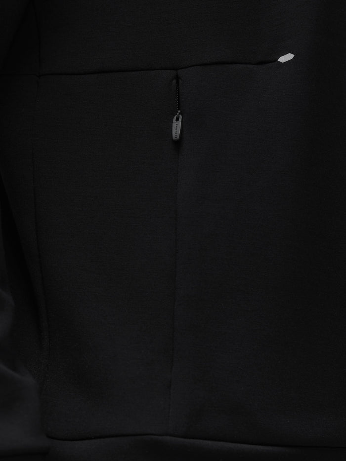 Close-up of black fabric with a centered zipper pull on a travel lifestyle sweatshirt.