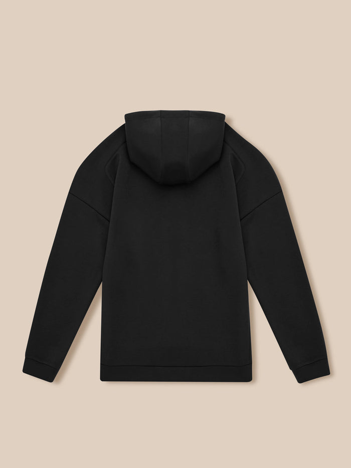 Back view of black travel lifestyle zip hoodie on a beige background