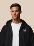 Male model in black travel zip hoodie with drawstring hood and left chest Castore logo over a white tee.