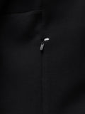 Close up of black travel hoodie fabric with a metal zipper pull and a white reflective patch.