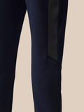 Close-up of a navy pant leg showing a black side panel and Castore branding along the seam.