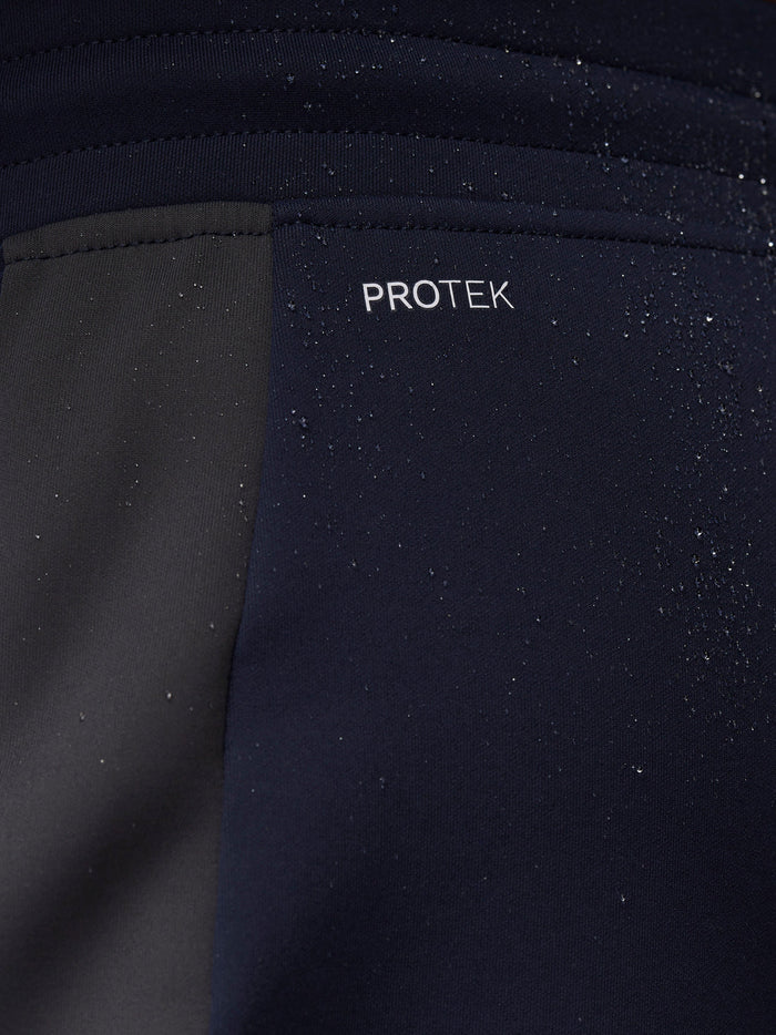 Close-up of navy Flex Thermo Pant fabric with ProTek branding and water droplets