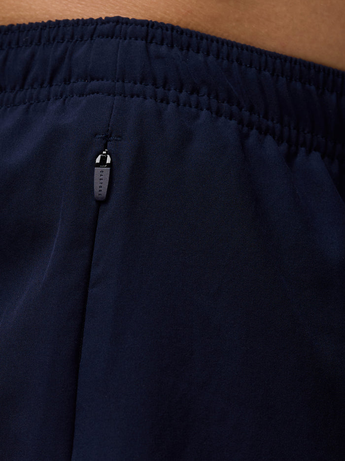 Close-up of the navy waistband and zipper pull on Apex 6 inch shorts.
