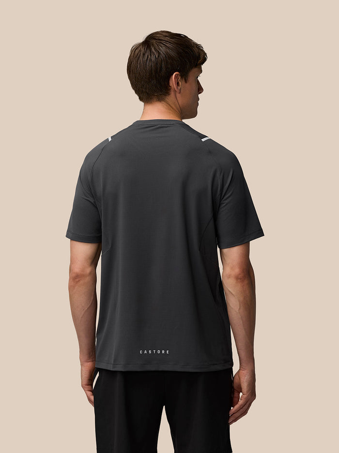 Back view of a man in a dark Apex Training T-shirt with Castore branding at the hem.