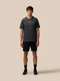 Man wearing dark gray Apex short sleeve T shirt with reflective shoulder accents and Castore logo on chest, black shorts