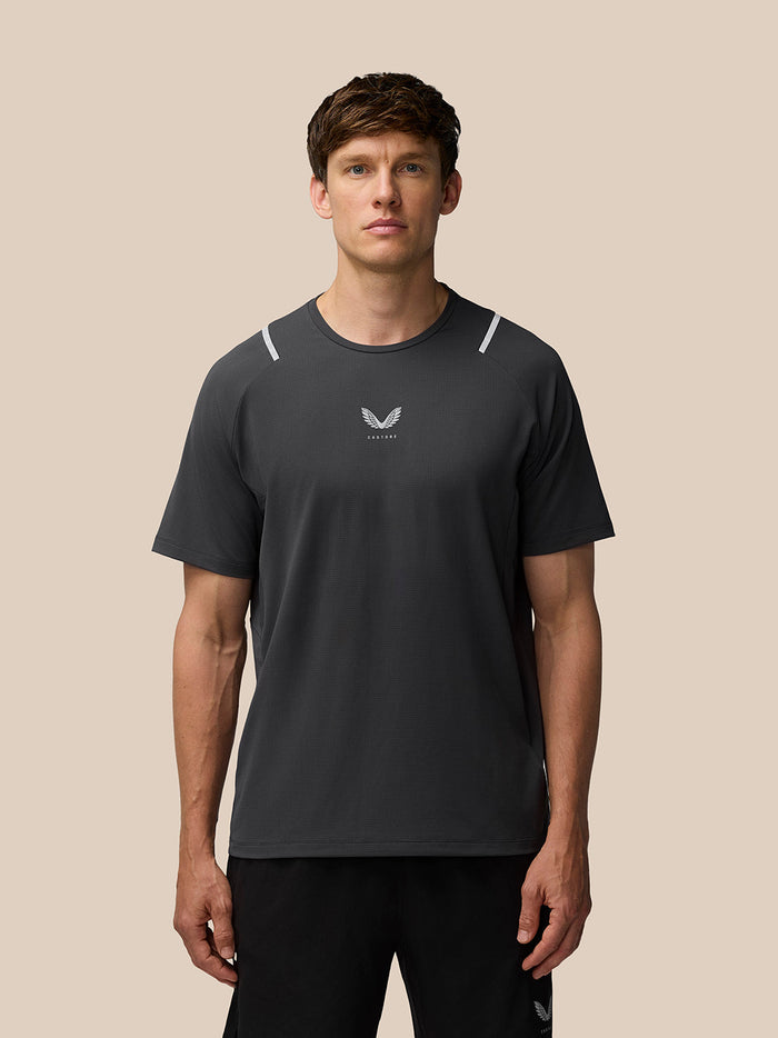 Rear view of a man wearing a gunmetal Apex Training T-shirt with reflective shoulder accents.