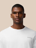 Close-up of a man wearing a white T-shirt with a small CASTORE logo on the chest.