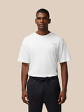 Front view of a male model in a white Flex Cotton T Shirt with a round neckline and CASTORE logo on the chest.