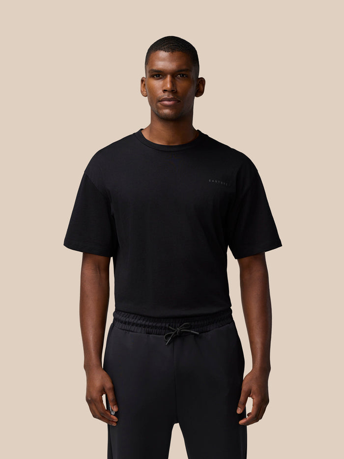 Male model wearing black FLEX Cotton T Shirt with short sleeves and small chest logo