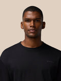 Front view of a man wearing a black short sleeve cotton T shirt with a small chest logo