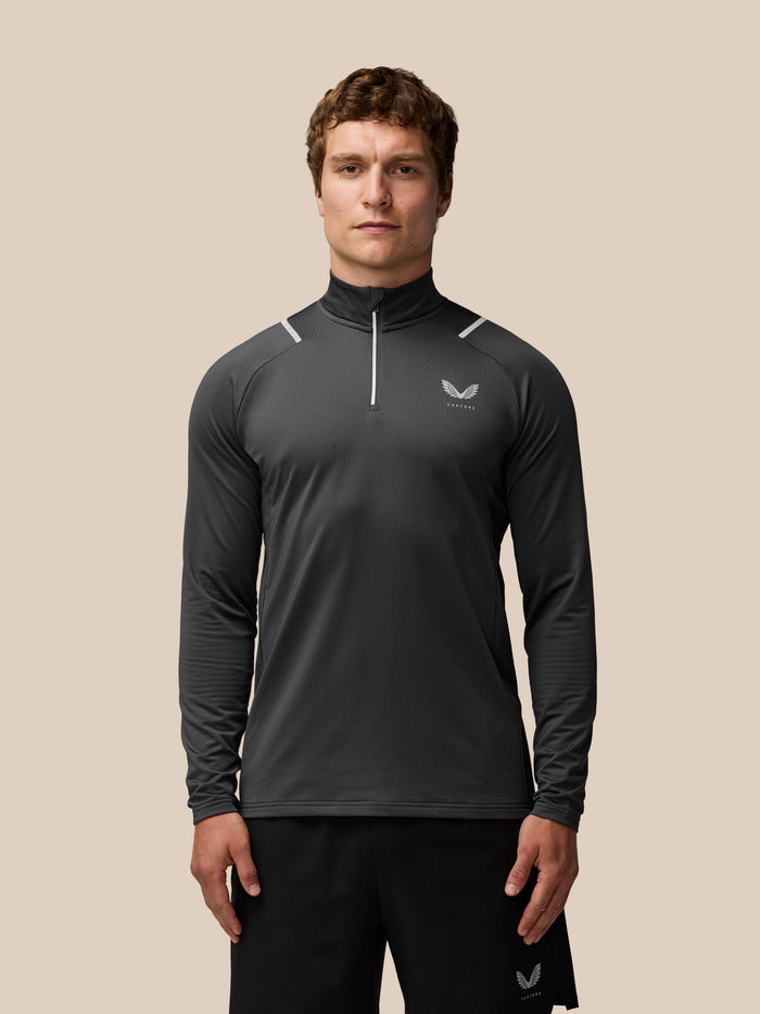 Front view of charcoal Apex Training Winterised quarter zip top on a model with reflective detailing